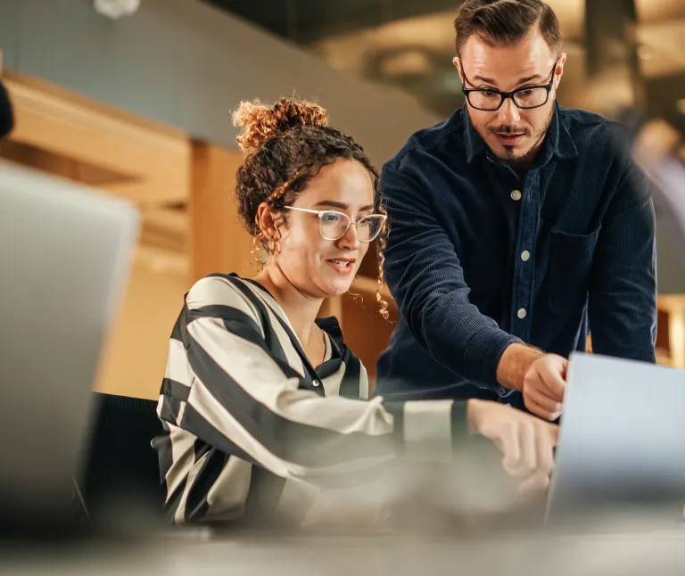 men and woman chating looking at computer